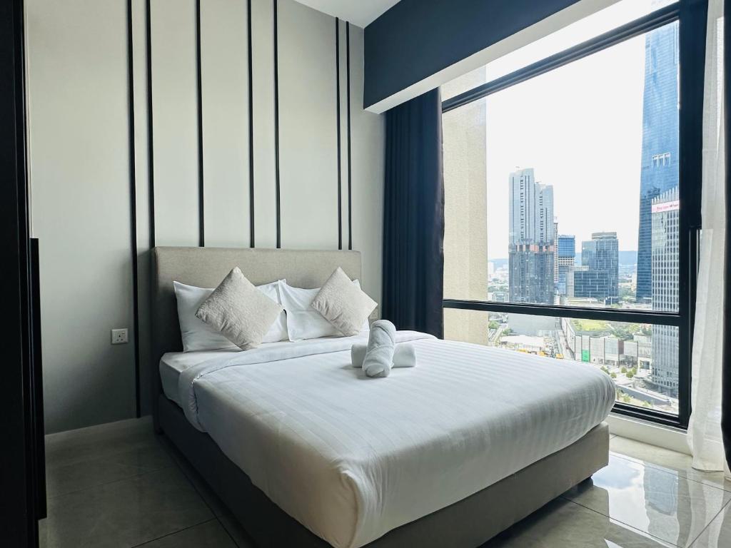 a bedroom with a bed with a teddy bear on it at The Axon Suites Pro Max in Kuala Lumpur