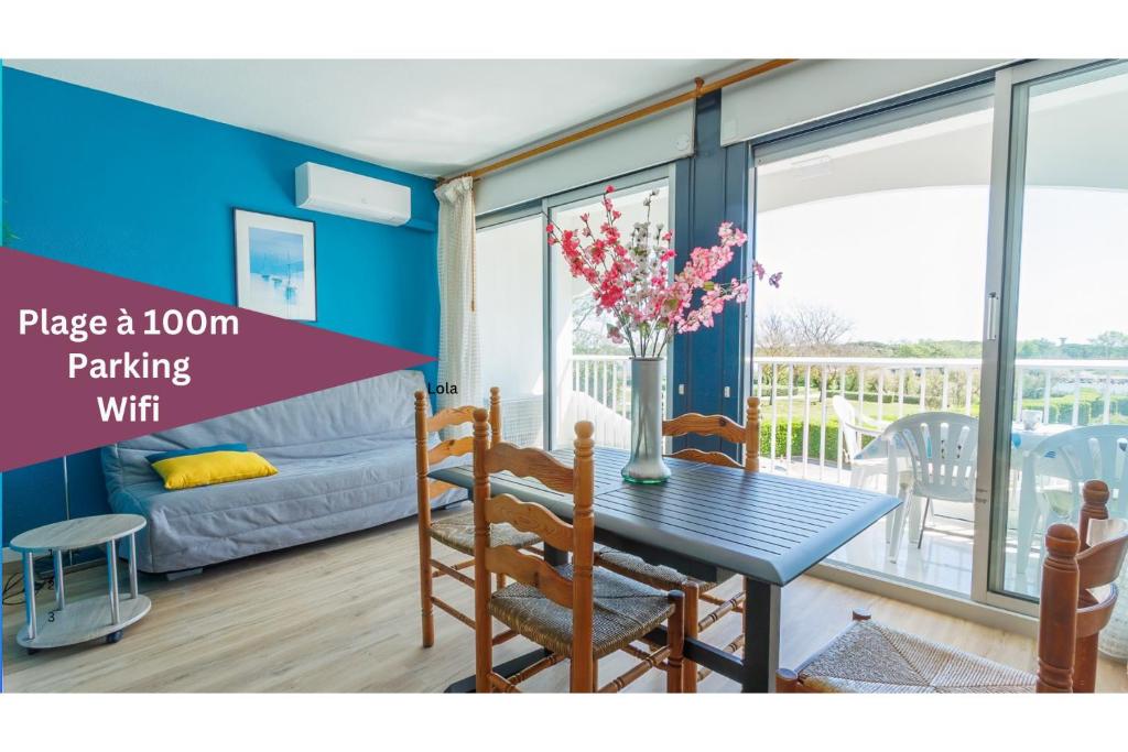 a room with a table and chairs and a couch at Mer et Dune in La Grande-Motte