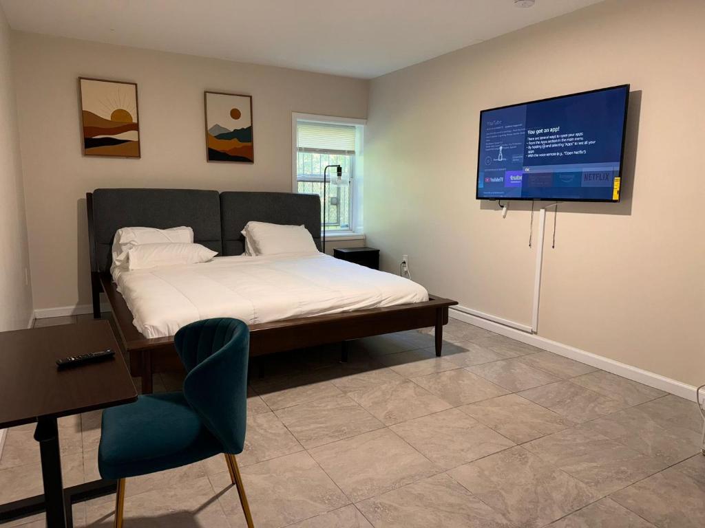 a bedroom with a bed and a flat screen tv at Cosy Bedroom 6 minutes to EWR Prudential Hotels Pen station in Newark