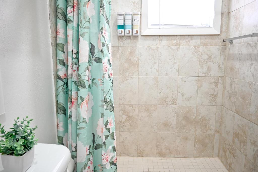 un bagno con tenda doccia e pianta di Nadiyah's Escape a Rock Sound