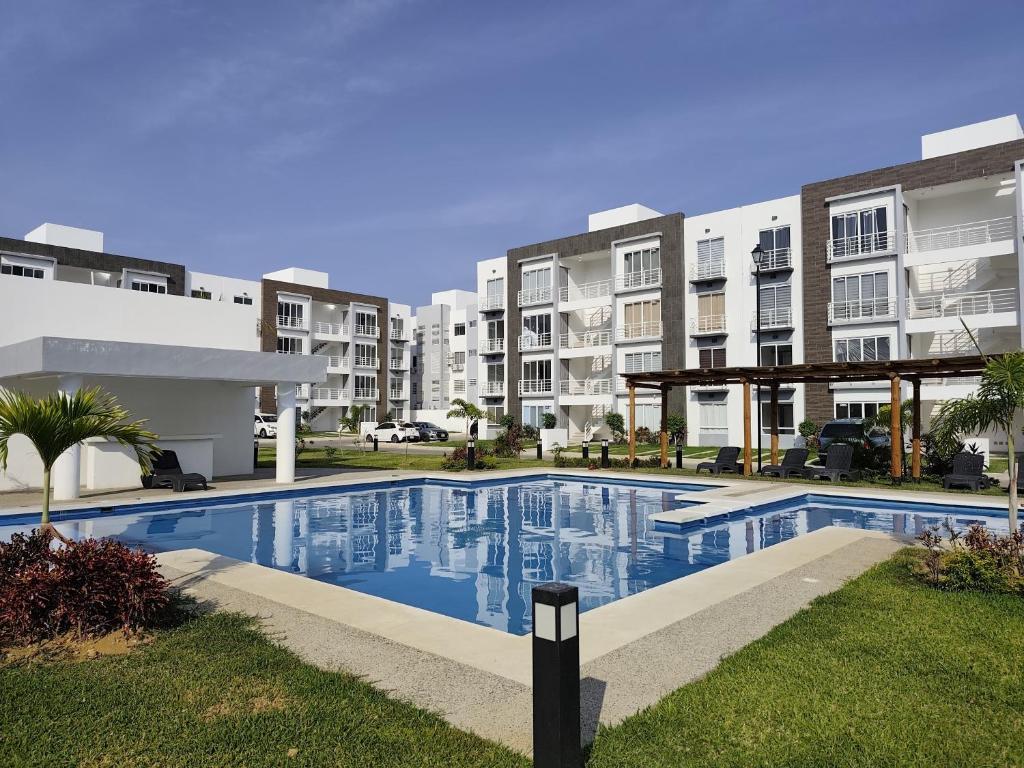 ein Schwimmbad vor einigen Wohnhäusern in der Unterkunft Comodo departamento en Barra Vieja Acapulco in Acapulco