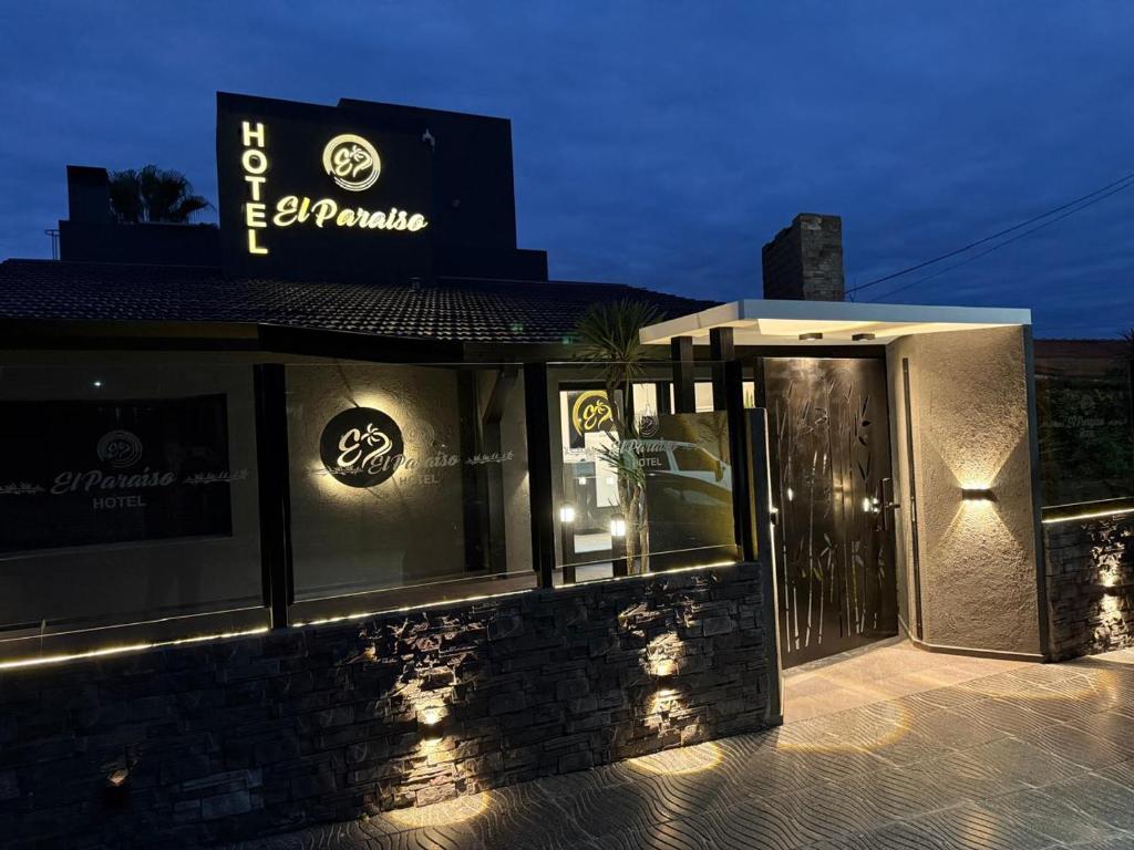 维拉卡洛斯帕兹Hotel El Paraiso Boutique的一间晚上在餐厅边有标牌的餐厅