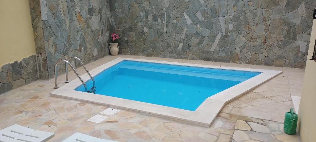 a swimming pool in a room with a stone wall at exclusive use swimming pool available from June to September in Cagliari