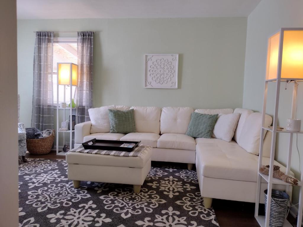 a living room with a white couch and a table at Sage Street Cottage in Winnsboro