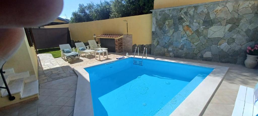 a swimming pool in a backyard with a stone wall at exclusive use swimming pool available from 1May to 30 October in Cagliari