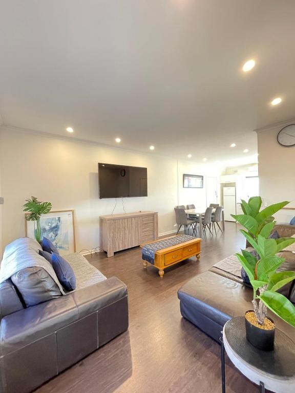 a living room with a couch and a table at Beach apartment 22 esplanade sea-views in Glenelg