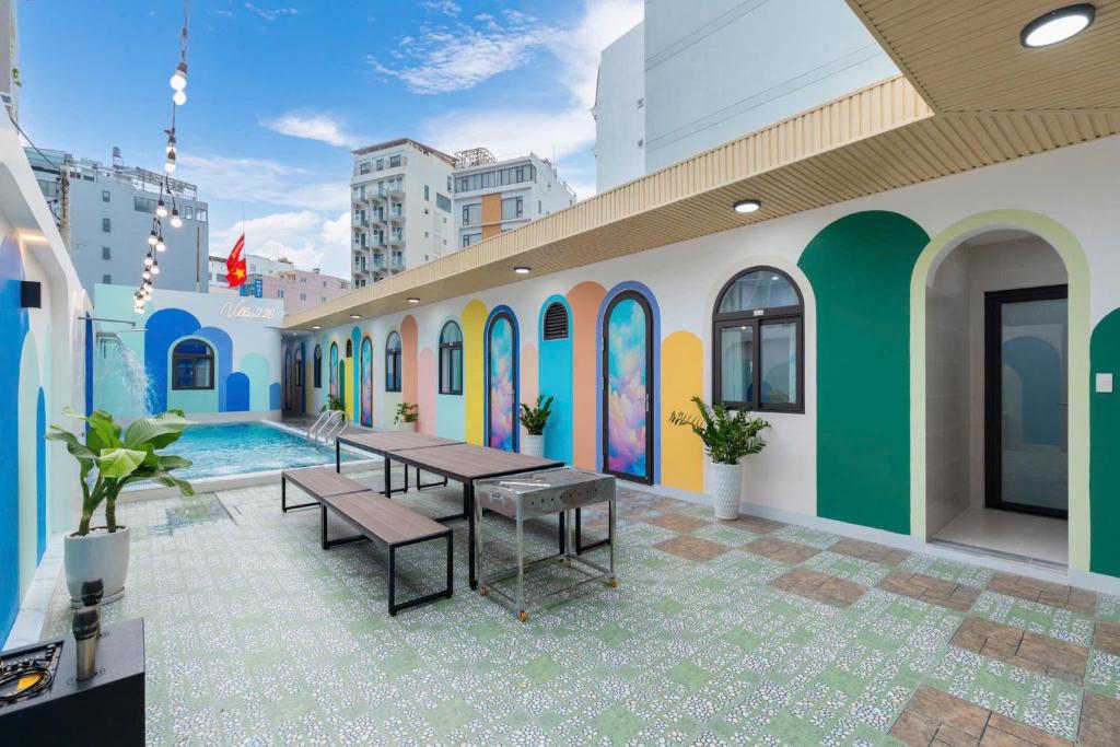 un edificio con piscina con tavolo e panchine di Sea Villla 81 Thùy Vân Đi Bộ 200 Met Ra Biển a Vung Tau
