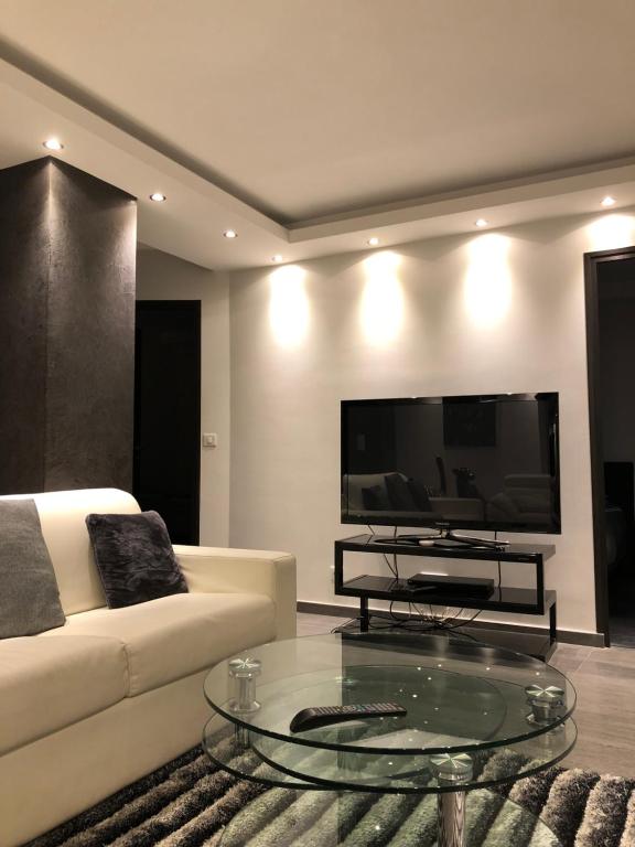 un salon avec un canapé blanc et une télévision dans l'établissement Luxury Loft Design Amazing en Plein coeur de Paris, à La Celle-sous-Gouzon