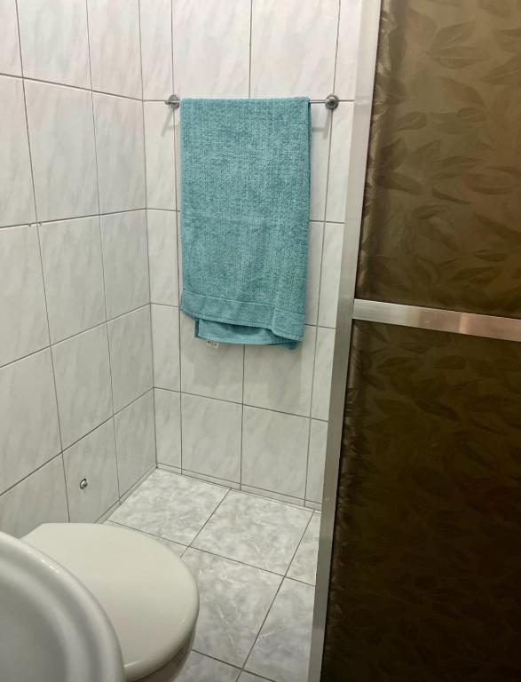 a bathroom with a toilet and a green towel at Studio no Largo da Carioca - Rio de Janeiro in Rio de Janeiro