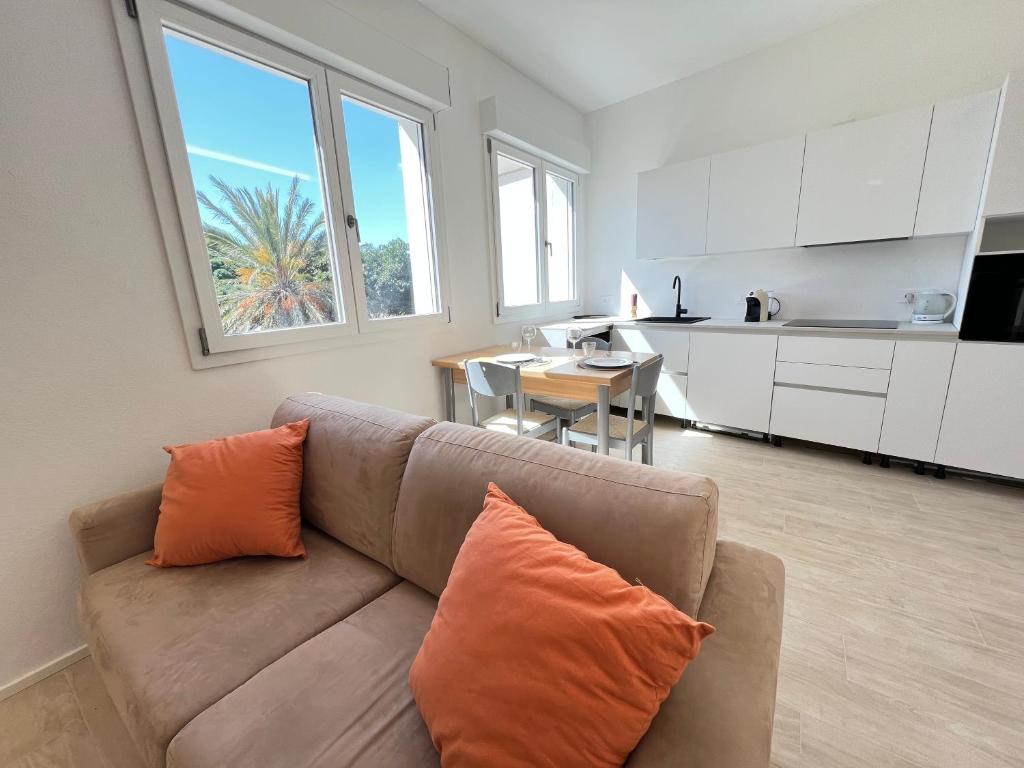 a living room with a couch and a kitchen at Moderno appartamento dí Beniamino Murgioni a Villasimius in Villasimius