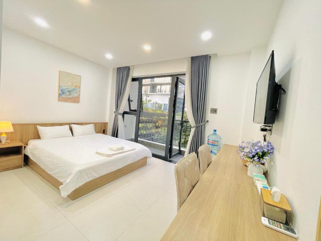 a bedroom with a bed and a table with a television at 501 Modern Studio with Balcony & Kitchen in Ho Chi Minh City