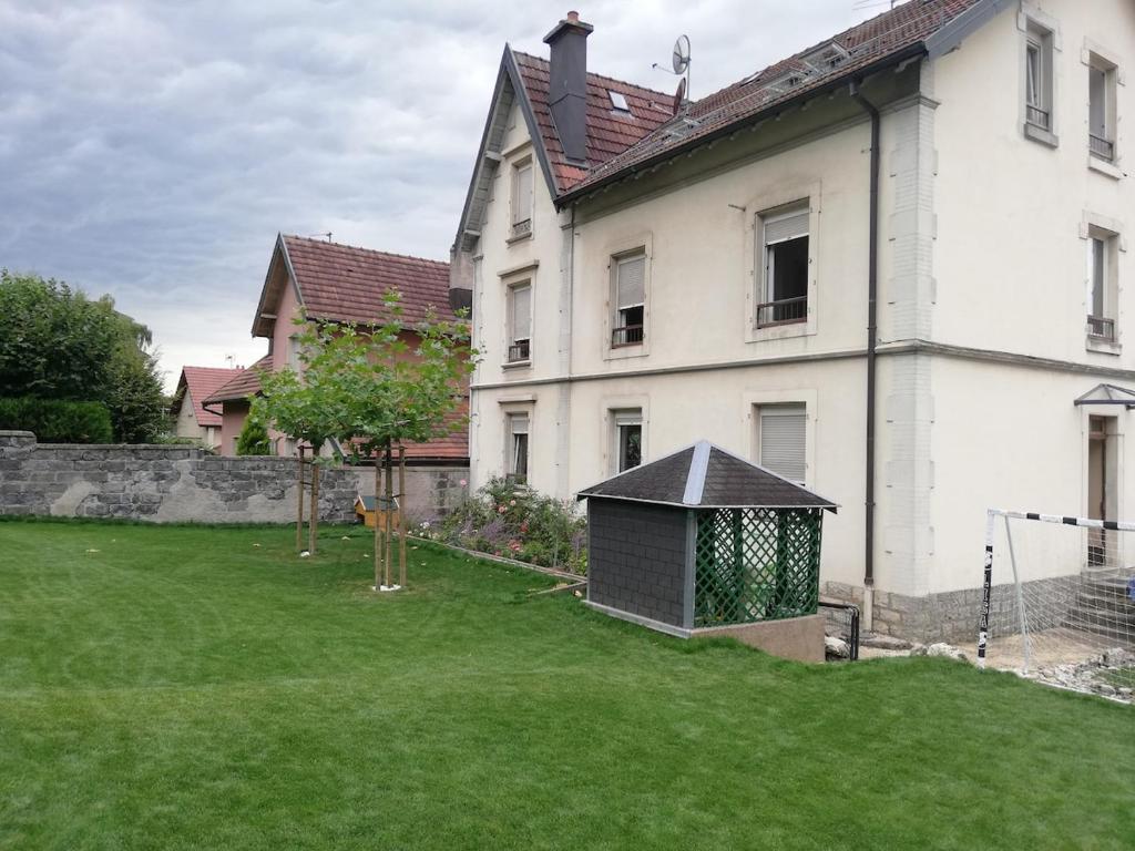 ein großes weißes Haus mit einem Garten davor in der Unterkunft Les 2 suites de Belfort 184m2 Centre Parkings in Belfort