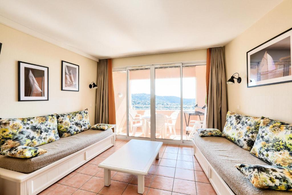 un salon avec un canapé et une table dans l'établissement Résidence le Hameau des Issambres - maeva Home - Appartement climatisé 2 pièces 5 personnes - Prestige MAE-3824, aux Issambres