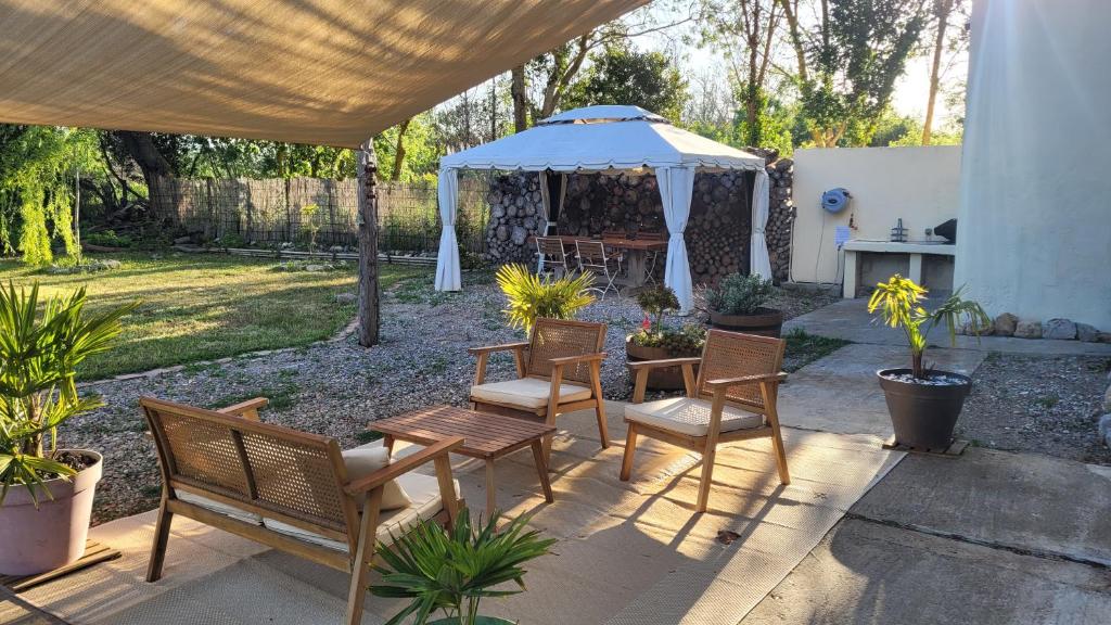 une terrasse avec des chaises et un kiosque dans l'établissement Le Clos des Oiseaux YourHostHelper, à Narbonne