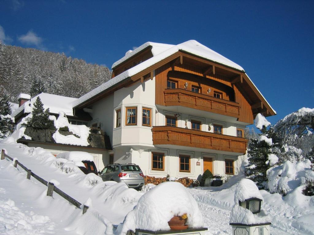 a snow covered house with a car in front of it at Gruber Alexandra in Sankt Michael im Lungau