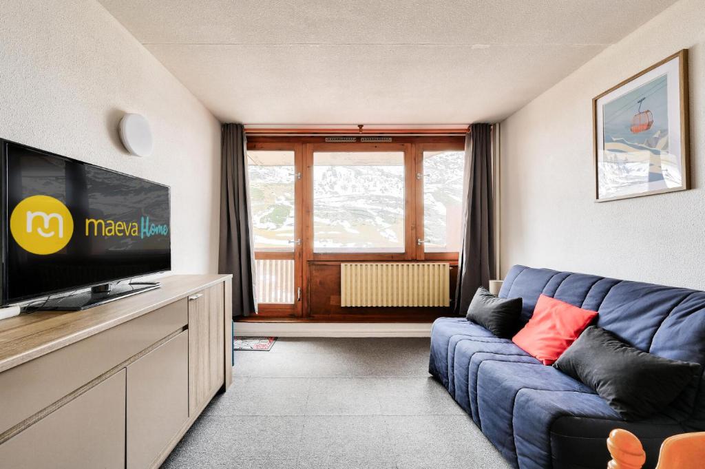 un salon avec un canapé bleu et une télévision dans l'établissement Résidence Le Tourmalet - maeva Home - Appartement 2 pièces 6 personnes - Confort MAE-7291, à La Mongie
