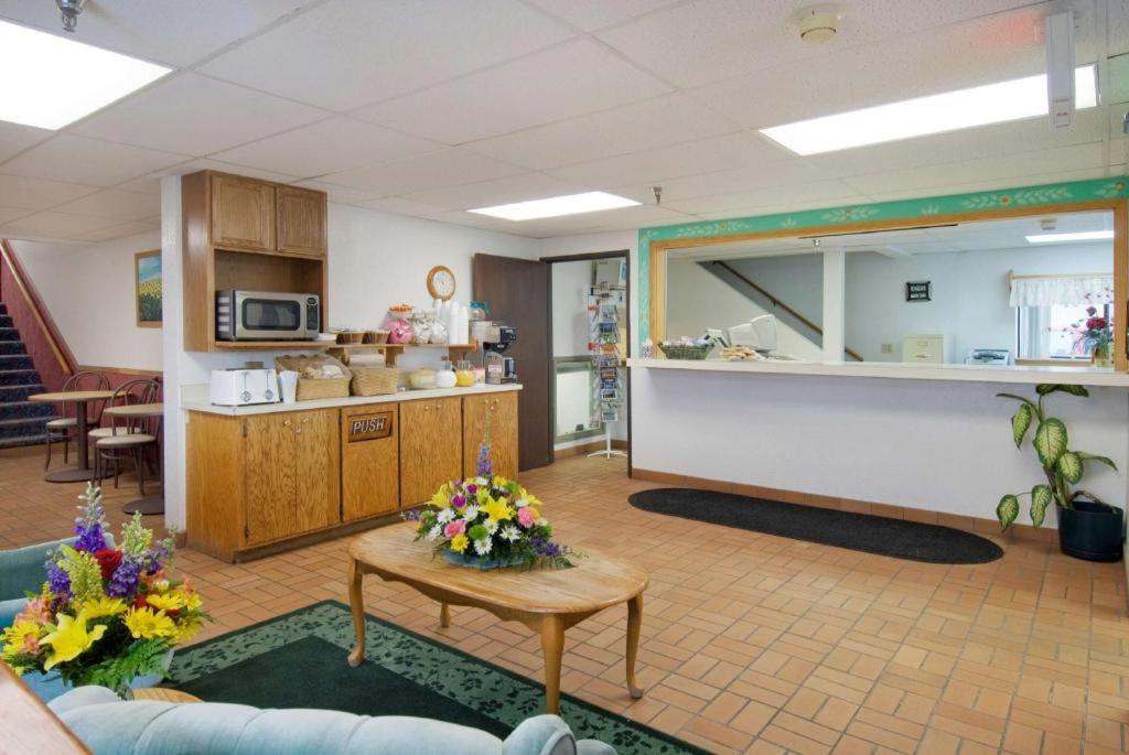 a waiting area of a hospital with a table and flowers at Americas Best Value Inn Torrington in Torrington