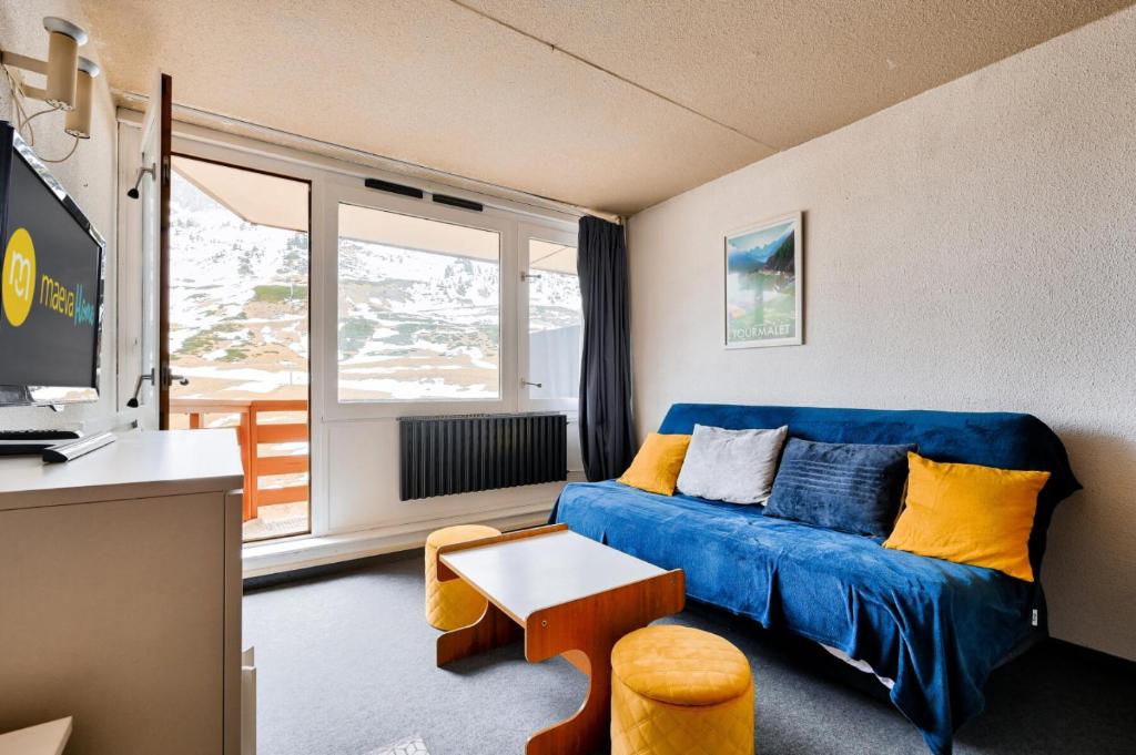 un salon avec un canapé bleu et une table dans l'établissement Résidence Le Tourmalet - maeva Home - Studio 4 personnes - Sélection MAE-0631, à La Mongie