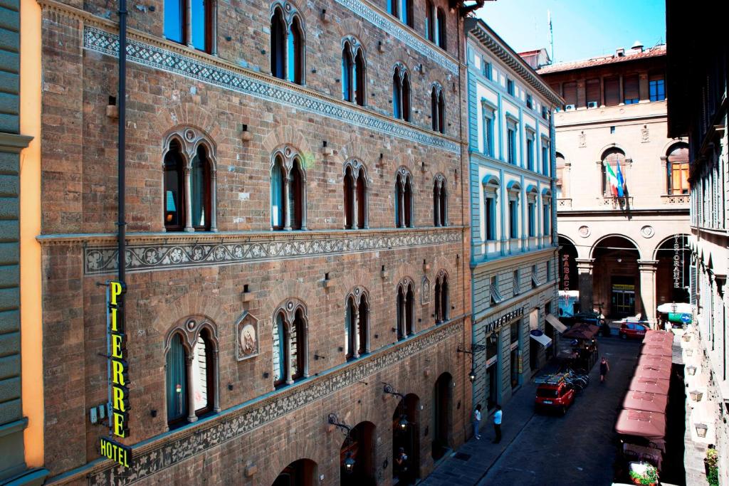 
a brick building with a clock on the side of it at Hotel Pierre in Florence
