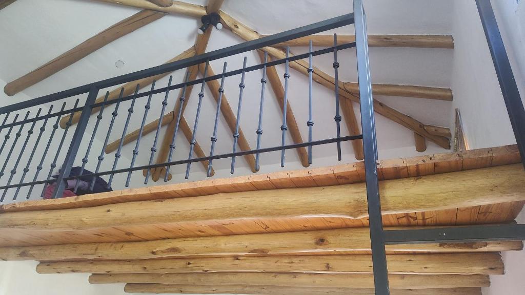 a set of wooden stairs with black metal railing at El descanso tiene nombre: Sonko in Tafí del Valle