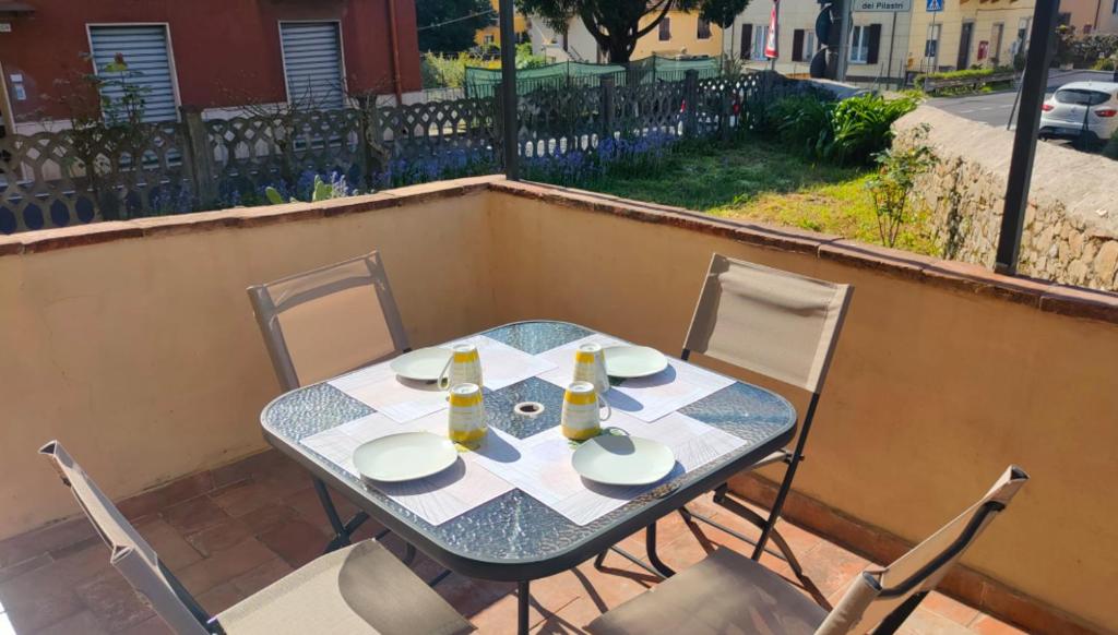 een tafel en stoelen op een balkon met een tafel en drankjes bij Casa Olga in La Spezia
