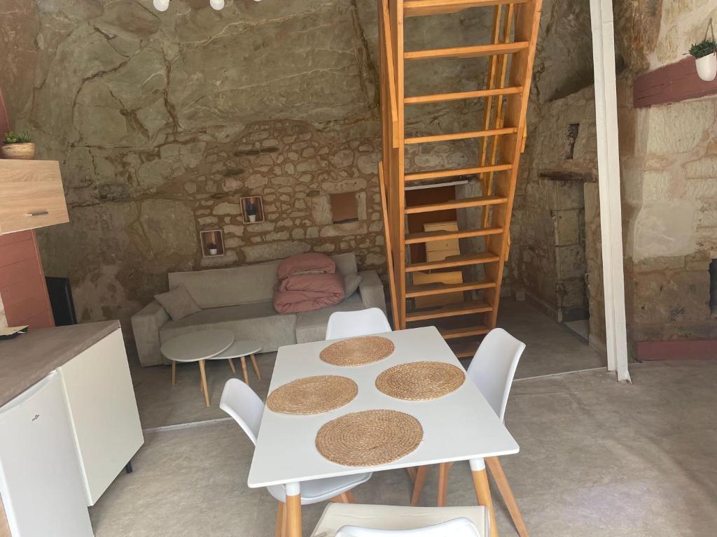 Una habitación con una mesa y sillas en una cueva. en La Cachette Futuroscope, en Beaumont