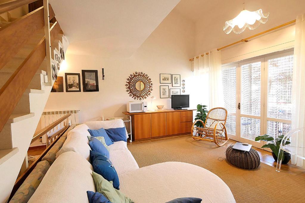 a living room with a couch and a tv at La Casetta Vicino al Mare in San Vincenzo