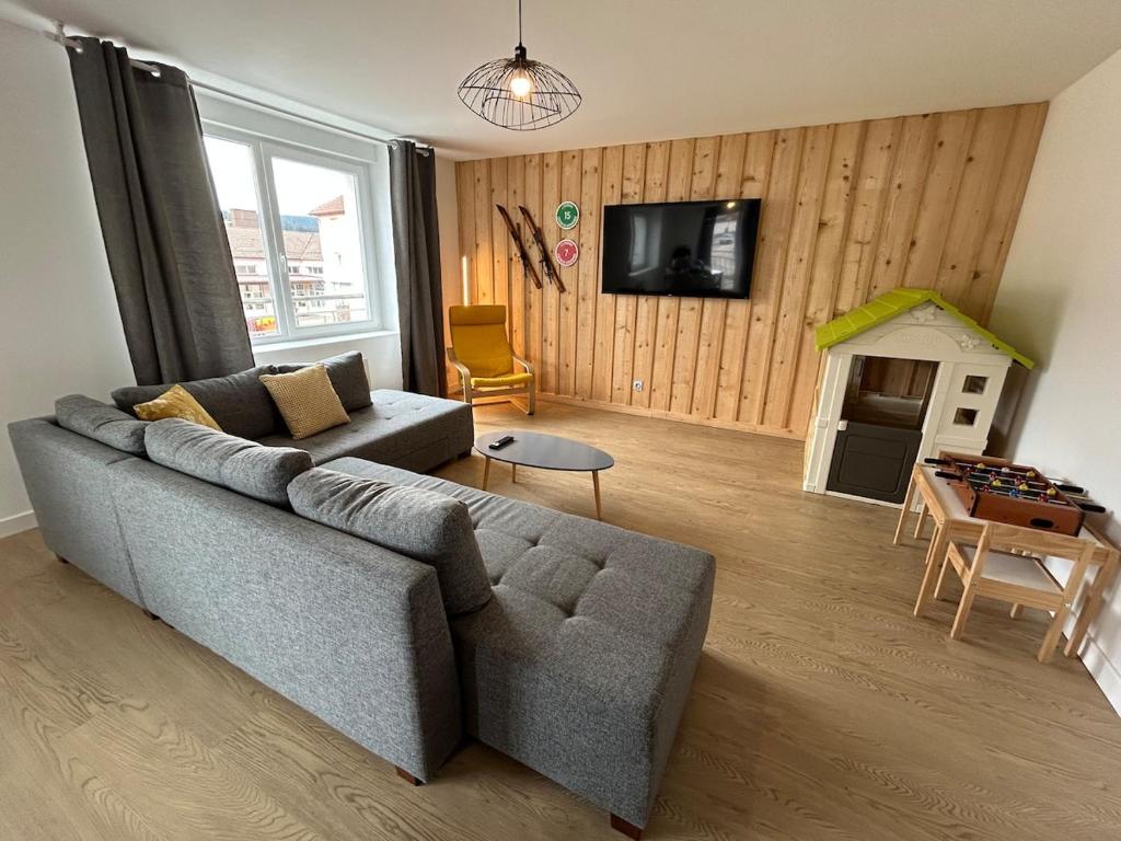 un salon avec un canapé et une table dans l'établissement La Jonquille, Appartement Centre Ville de Gérardmer, linge et ménage inclus, à Gérardmer