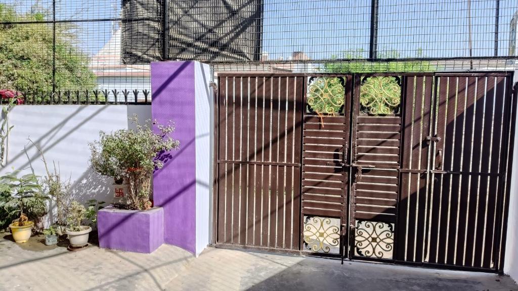 a gate with purple and purple walls and plants at Maa Bhagwati Home stay & PG House in Ayodhya