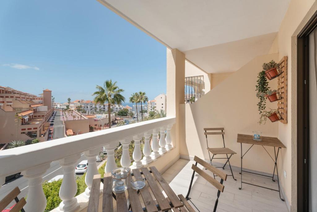 a balcony with a table and chairs and a view of the city at Estupendo Estudio En Castle Harbour in Los Cristianos