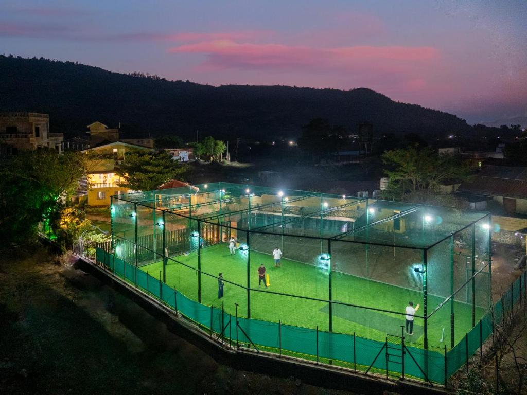 a tennis court with people on it at night at Newly Renovated-Farm Villa -6BHK with Pool & Turf in Lonavala