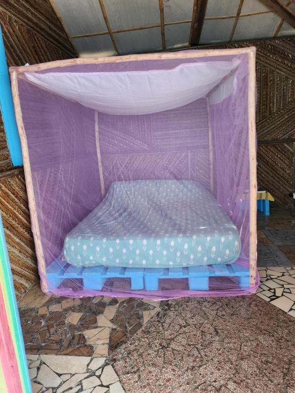 a purple tent with a bed in it at Casa mwezi in Memboua Bouani