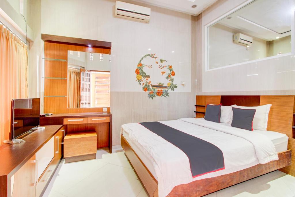 a bedroom with a bed and a desk and a sink at Hotel O Yogyakarta near MM UGM formerly Bama Guesthouse in Yogyakarta