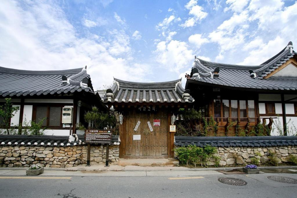 Un edificio de estilo asiático con techo en una calle. en Jeonju Hanok Ihwa Gotaek Banchayougi Josik, en Jeonju