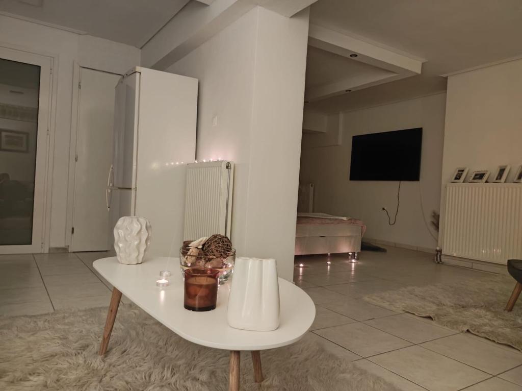 a living room with a white table and a tv at Basement Suite in Tríkala