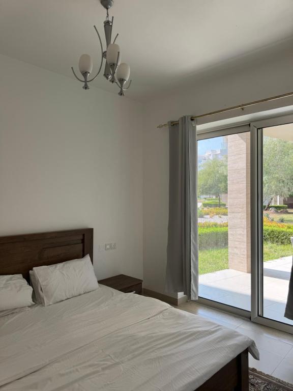 a bedroom with a bed and a large window at منتجع جبل السيفه in Muscat