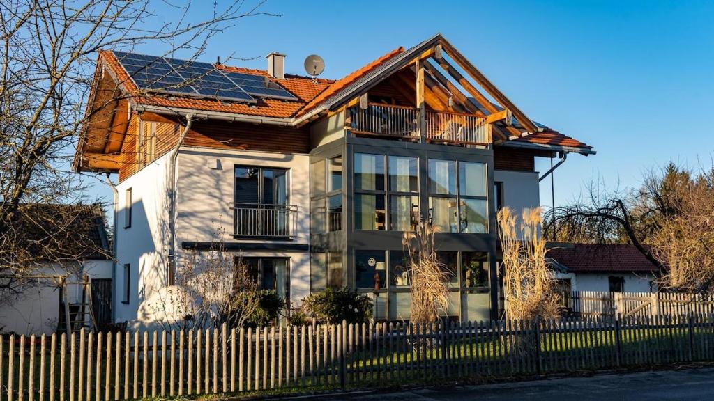 a white house with a fence in front of it at Apartment Nanni in Kirchanschöring