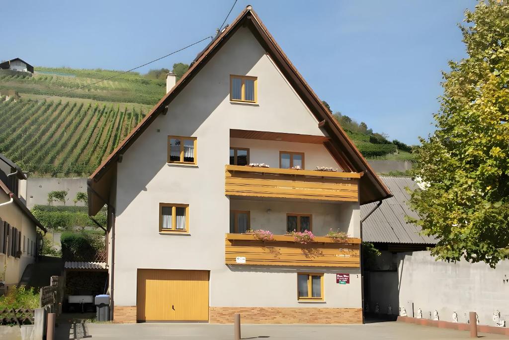 a white house with a gambrel roof at Gästehaus zum Schlossberg in Vogtsburg