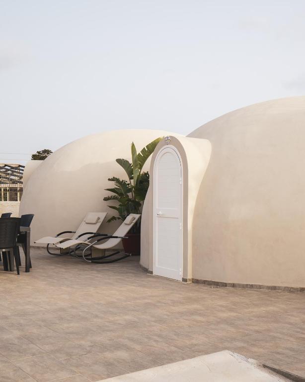 un edificio bianco con una porta bianca e una pianta di Nausicaa Guesthouse a Marsala
