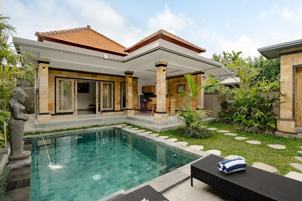 una villa con piscina frente a una casa en Puri Sedana Ubud Villa, en Ubud