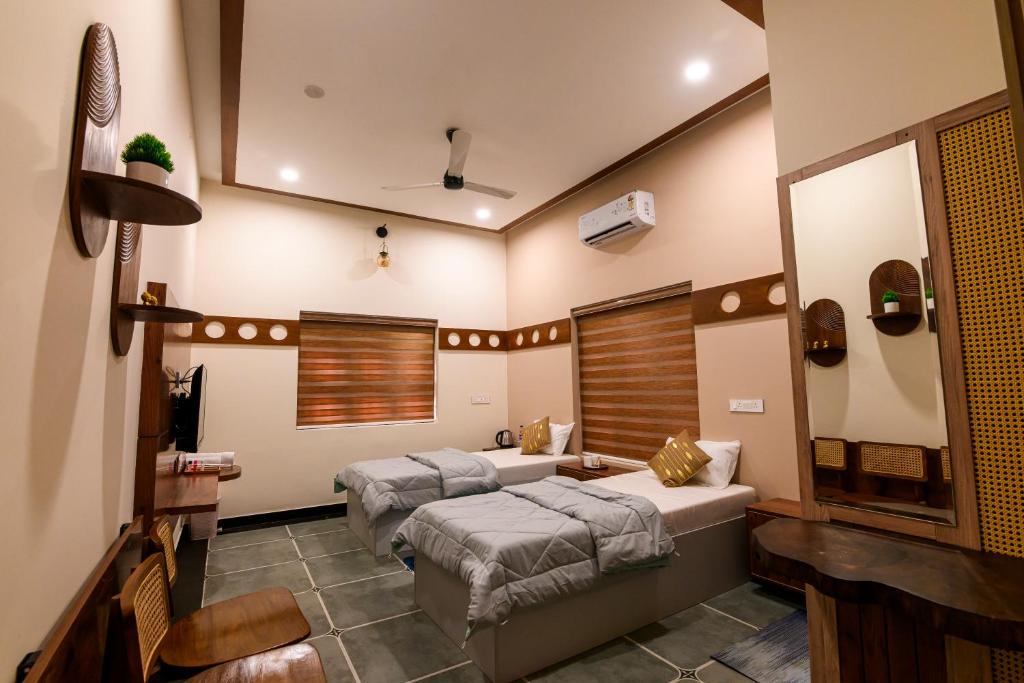 a bedroom with two beds and a mirror at Dr Indulekhas Ayurvedic Wellness And Rejuvenation in Tellicherry