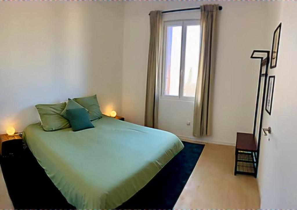 a bedroom with a large bed with a window at Elegance Centre Sète in Sète