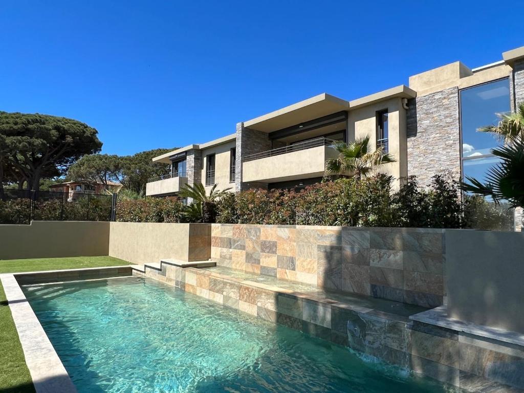une maison avec une piscine devant une maison dans l'établissement La Croisette, YourHostHelper, à Sainte-Maxime