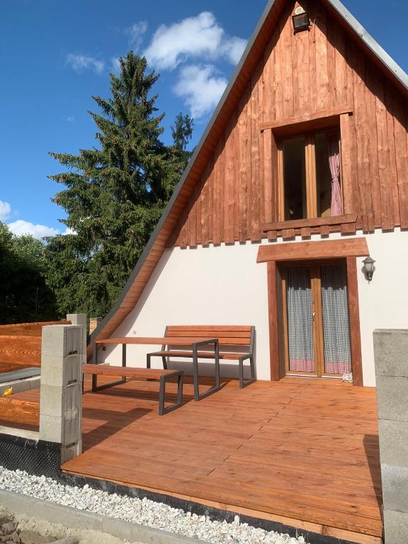 a building with two benches on a wooden deck at U Cejhonů in Měděnec