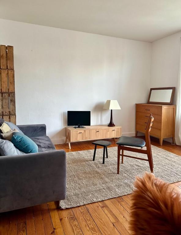 un salon avec un canapé et une chaise dans l'établissement Appartement spacieux de 3 chambres pour 6 personnes, à Clermont-Ferrand
