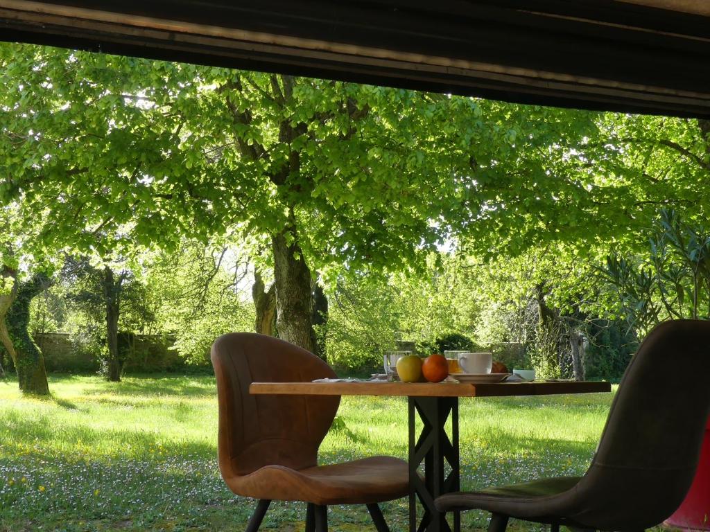 a table with fruit on it under a tree at Hôtel et SPA du Château in Lagord