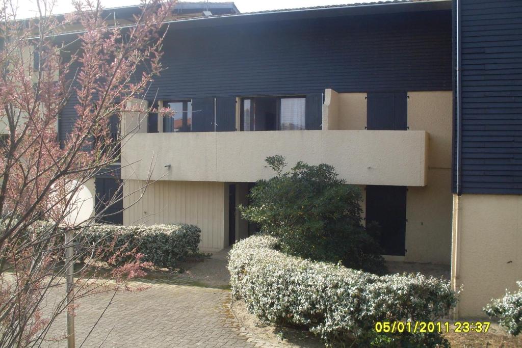 un bâtiment avec des buissons devant lui dans l'établissement Appartement 4 personnes Seignosse Océan, à Seignosse