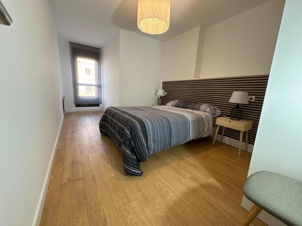 a bedroom with a bed and a wooden floor at La Glicinia VUT-7355-AS in Cangas de Onís