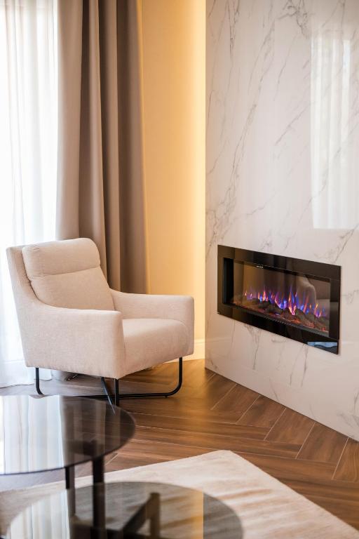 a living room with a chair and a fireplace at Ideal Apartments in Banja Luka
