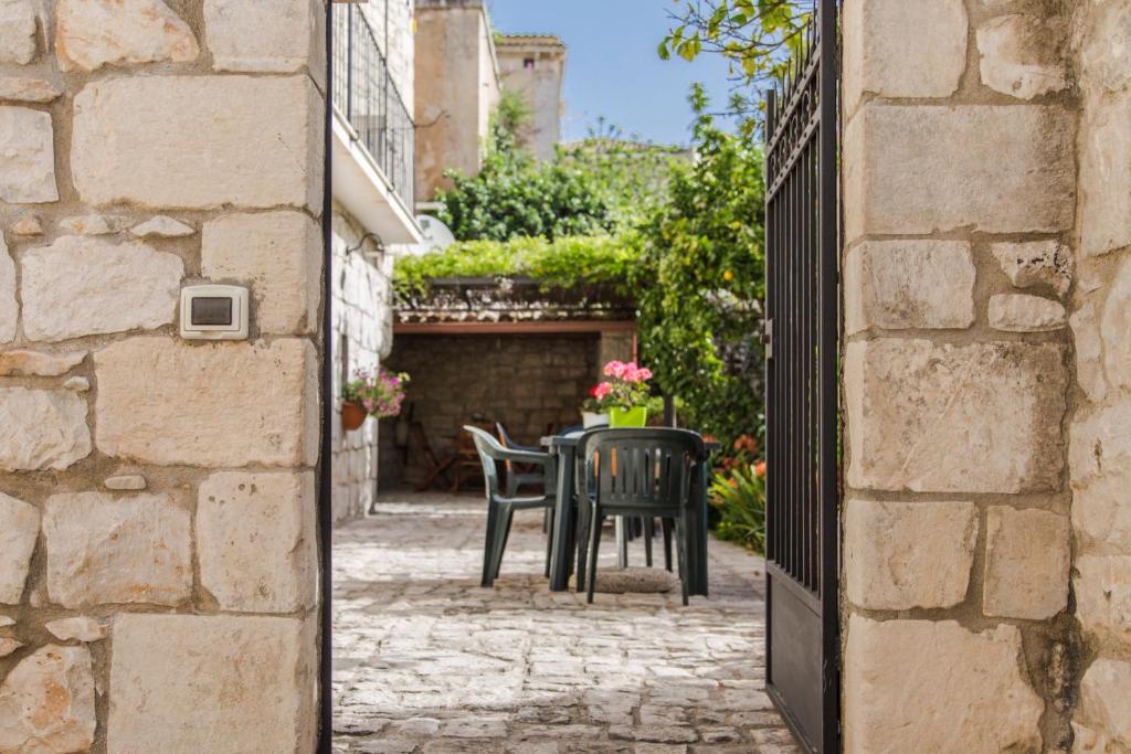 a patio with a table and chairs in an alley at B&B Il Giardino Dei Mandarini in Modica